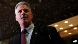 FILE - Former Massachusetts Sen. Scott Brown talks with media at Trump Tower, Nov. 21, 2016, in New York. 