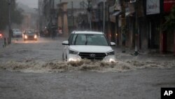 A car moves through a flooded street during monsoon rains Jammu, India, Monday, July 12, 2021. India’s monsoon season runs from June to September. (AP Photo/Channi Anand)