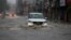 A car moves through a flooded street during monsoon rains Jammu, India, Monday, July 12, 2021. India’s monsoon season runs from June to September. (AP Photo/Channi Anand)