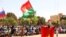 FILE - A man holds his national flag as people gather to show their support to the Junta leader Ibrahim Traore and demand the departure of the French ambassador in Ouagadougou, Burkina Faso January 20, 2023.