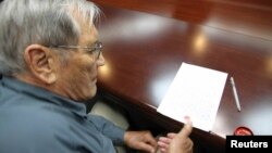Esta foto muestra a Merrill Newman cuando estampa su huella digital en un documento preparado por Corea del Norte.