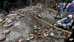 FILE - Investigators collect evidence at the site of an explosion, in Lahore, Pakistan, June 23, 2021.