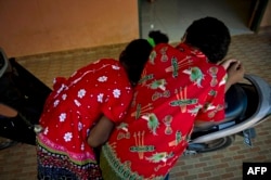 Fifi (11 tahun) yang terinfeksi AIDS dari ibunya berbincang dengan Miguel (10 tahun) yang ibunya seorang ODHA di Rumah Surya Kasih, Desa Waena, Papua, 10 Mei 2015. (Foto: AFP)