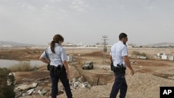 Israeli police inspect the site where a rocket landed on the outskirts of the Israeli Red Sea resort of Eilat, 02 Aug 2010