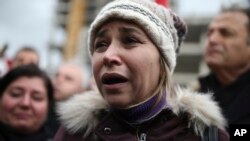 A woman reacts as police officers carry the coffin of police officer Fethi Sekin, who was killed in a car bomb attack, during his funeral in the Aegean city of Izmir, Turkey, Jan. 6, 2017.