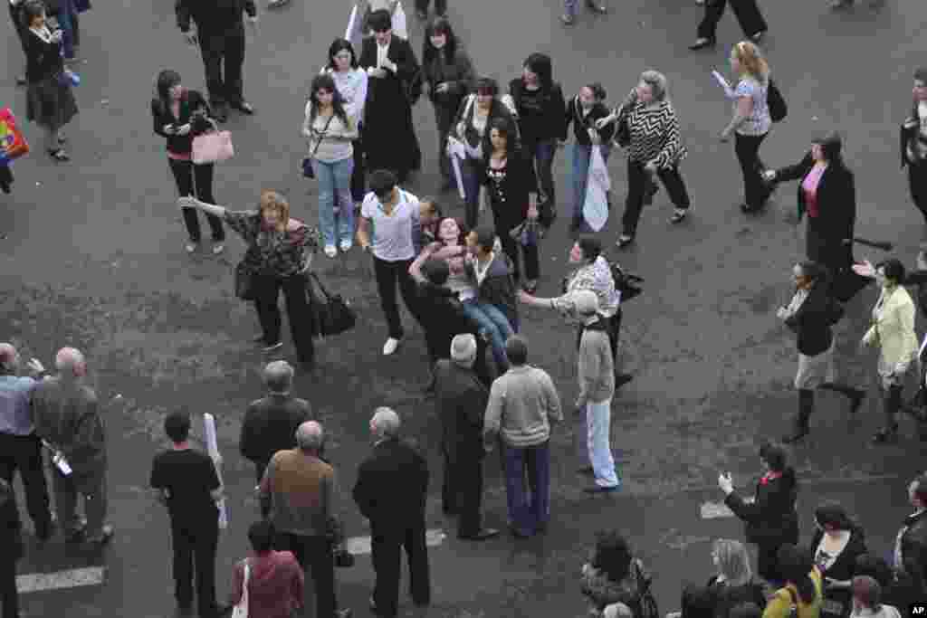 People carry a victim (C) of the explosion of gas-filled balloons during a campaign rally in the central Republic Square in Yerevan, May 4, 2012. An explosion injured at least 144 in central Yerevan on Friday during a campaign rally by Armenia's ruling pa