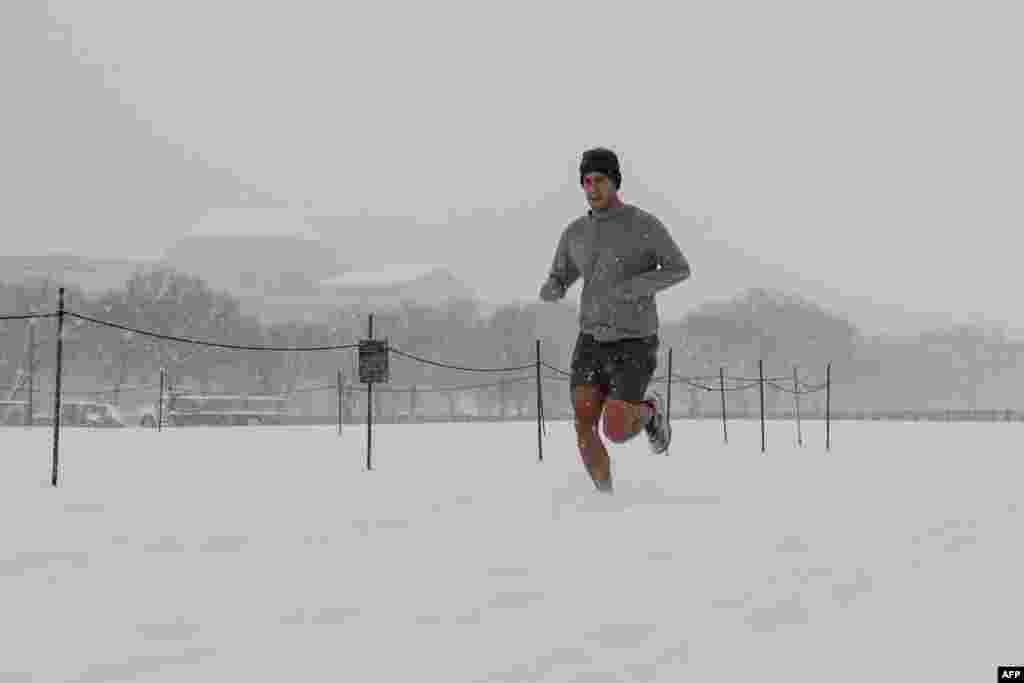 Un hombre corre por el National Mall mientras cae nieve durante una tormenta invernal en Washington.