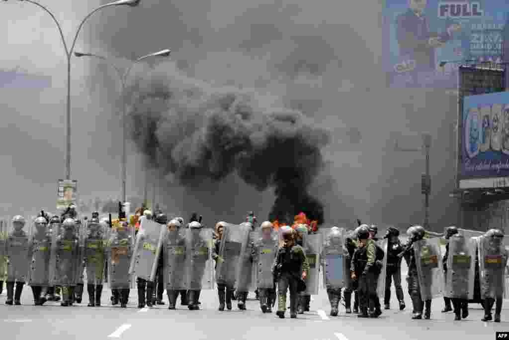 Riot police take positions during clashes with demonstrators protesting against President Nicolas Maduro's government in Caracas, Venezuela.