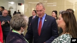 Newly sworn-in Interior Secretary Ryan Zinke, and his wife Lola, right, greets an Interior Department employee on the Interior Department's 168th birthday, March 3, 2017, at the Interior Department in Washington.