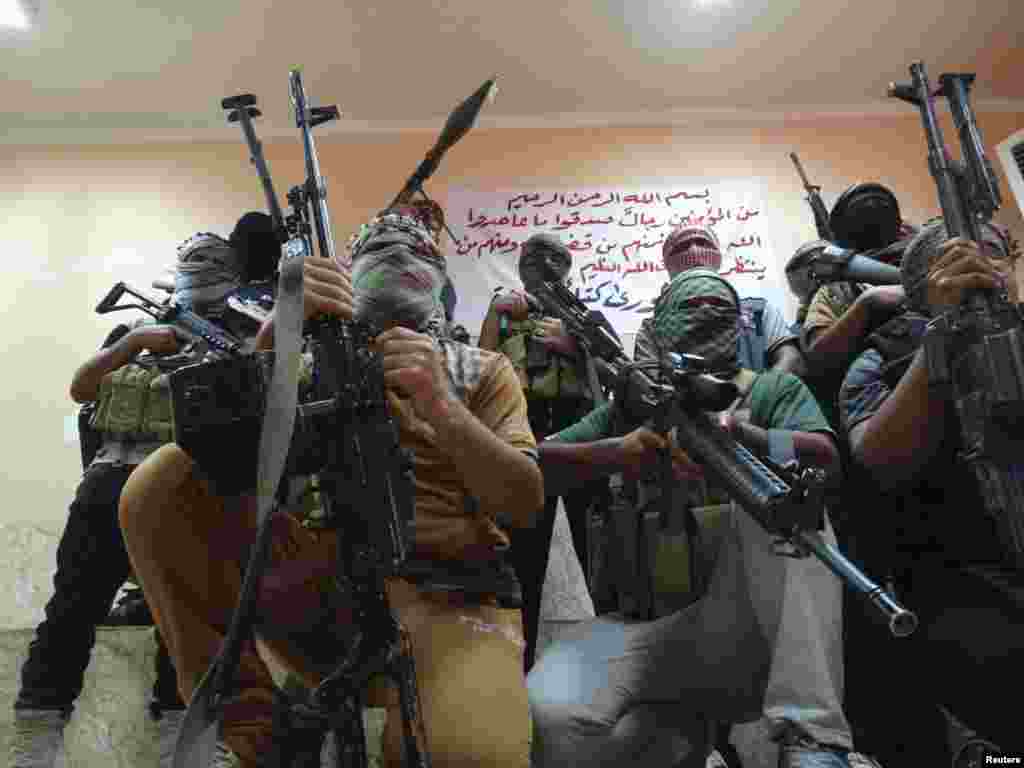 Tribal fighters pose for photographs with their weapons&nbsp;during an intensive security deployment to fight militants of the Islamic State, in the town of Haditha, northwest of Baghdad, Iraq, Aug. 28, 2014.