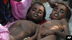 Two Somali children suffering from malnutrition lie at a camp for Internally Displaced People (IDP) near Mogadishu airport. The IDP's at the camp are facing dire humanitarian crises including lack of proper shelter, clean water, medicine and sufficient fo