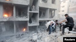 Men search for survivors at a site activists said was hit by heavy shelling by forces loyal to Syria's President Bashar al-Assad in the Douma neighborhood of Damascus June 16, 2015.