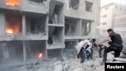 FILE - Men search for survivors at a site activists said was hit by heavy shelling by forces loyal to Syria's President Bashar al-Assad in the Douma neighborhood of Damascus, June 16, 2015.