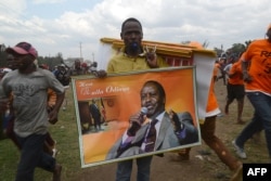 FILE - A vendor sells merchandise with images of Kenya's opposition leader Raila Odinga of the opposition National Super Alliance (NASA) coalition at a political rally Nairobi on Oct. 18, 2017.