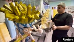 Yucel Bas prepares fries at Bas Frietjes frites stands in Sint Pieters Leeuw, Belgium, Dec. 4, 2014. (REUTERS/Yves Herman) 