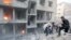 FILE - Men search for survivors at a site activists said was hit by heavy shelling by forces loyal to Syria's President Bashar al-Assad in the Douma neighborhood of Damascus, June 16, 2015.
