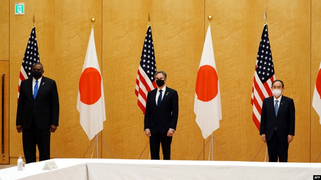 美國國務卿布林肯（中）和美防長奧斯汀（左）在東京與日本首相菅義偉合影。（法新社2021年3月16日）