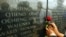 FILE - A woman puts flowers in front of the memorial with the names of the 213 people who died during the 1998 U.S. Embassy bomb blast, in Nairobi, Kenya, Aug. 7, 2002.