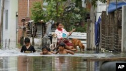 Residents travel on a flooded street in Phnom Penh September 26, 2011.The death toll from flooding in Thailand since mid-July has risen to 158, while 61 people have died in neighbouring Cambodia in the past two weeks, authorities in the two countries said