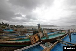 A fisherman carries his tools as he leaves for a safer place after tying his boats along the shore ahead of Cyclone Fani in Peda Jalaripeta on the outskirts of Visakhapatnam, India, May 1, 2019.