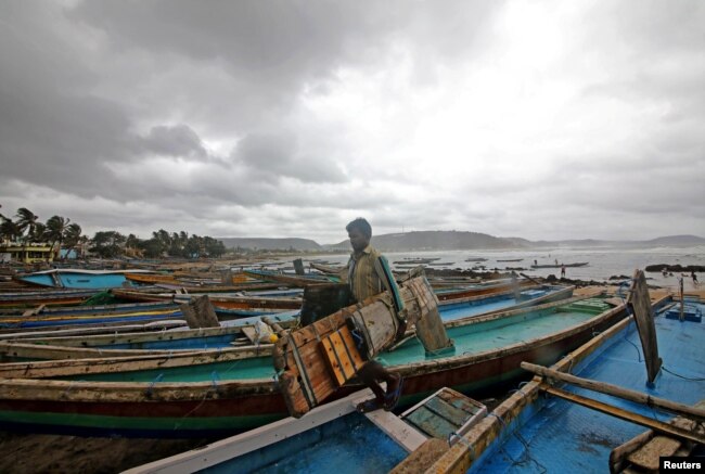 A fisherman carries his tools as he leaves for a safer place after tying his boats along the shore ahead of Cyclone Fani in Peda Jalaripeta on the outskirts of Visakhapatnam, India, May 1, 2019.