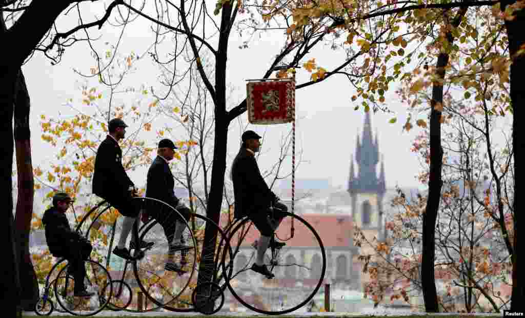 Para peserta mengenakan kostum bersejarah naik sepeda roda tinggi selama lomba tradisional tahunan di Praha, Republik Ceko.