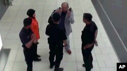 Kim Jong Nam (traje claro), el exiliado medio hermano de Kim Jong Un, habla con la policía luego de ser atacado en el aeropuerto de Kuala Lumpur, Malasia