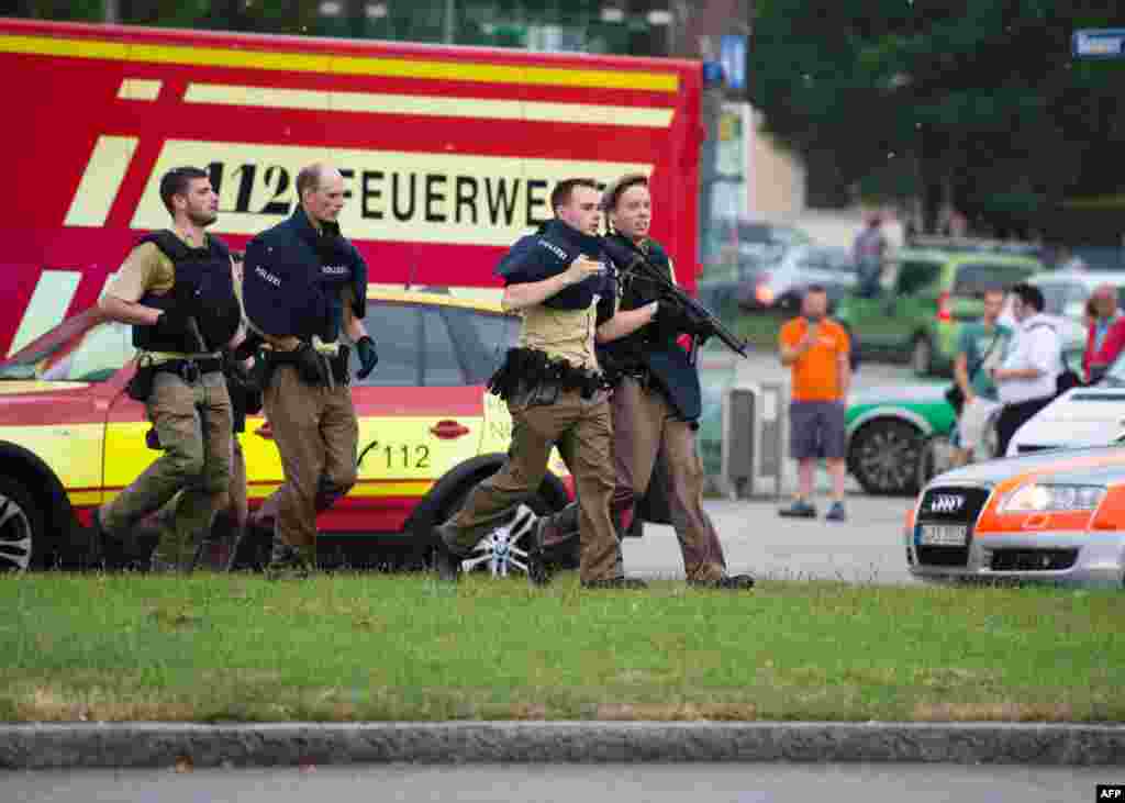 Police walk near a shopping center in Munich were a guman shot several people July 22, 2016.