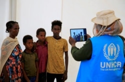 A humanitarian worker from UNHCR, documents Ethiopian refugees fleeing from the ongoing fighting in Tigray region, at the Um-Rakoba camp, on the Sudan-Ethiopia border, in the Al-Qadarif state, Sudan, Nov. 23, 2020.