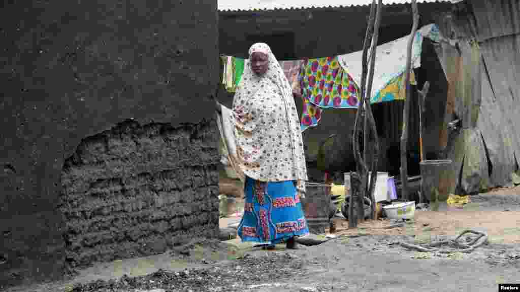 A woman stands next to a burnt house in the aftermath of what Nigerian authorities said was heavy fighting between security forces and Islamist militants in Baga
