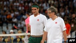 Roger Federer, à gauche et Bill Gates lors d'un match de gala à Cape Town, Afrique du Sud, le 7 février 2020.