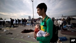 Un réfugié afghan de 15 ans, Rasoul Nazari, 15, et son neveu de dix mois, Imran, à la frontière entre l'Autriche et la Hongrie, 23 septembre 2015.