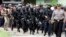 Members of the anti-terror police arrive at the village of Batu Rengat, where police exchanged fire with suspects in a house in Bandung, West Java province, May 8, 2013. 