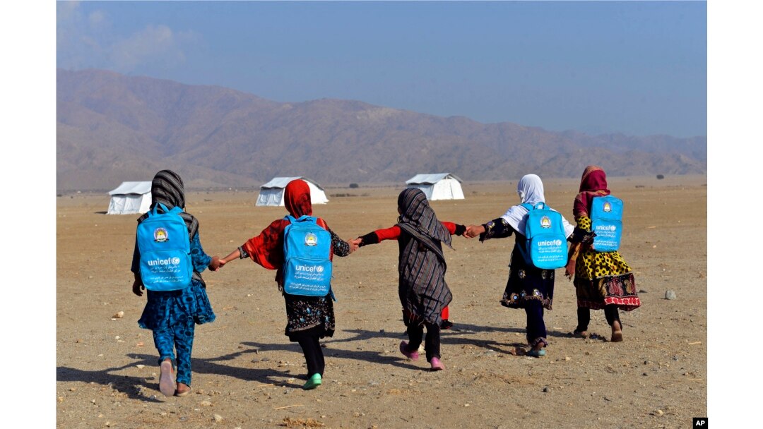 Afghan schoolgirls walk towards their tent classrooms on the outskirts of Jalalabad, capital of Nangarhar province, Afghanistan, Dec. 13, 2016.