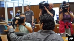 Al-Qaida suspect Rami Makanesi greets friends prior to the start of his trial in a court room in Frankfurt, May 9, 2011