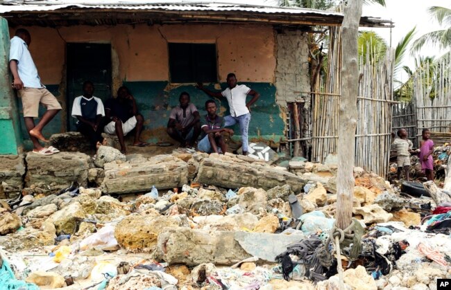 FILE - Local residents look at rubble and other items washed close to their doorstep when Cyclone Kenneth struck, in Pemba city on the northeastern coast of Mozambique, April, 27, 2019.