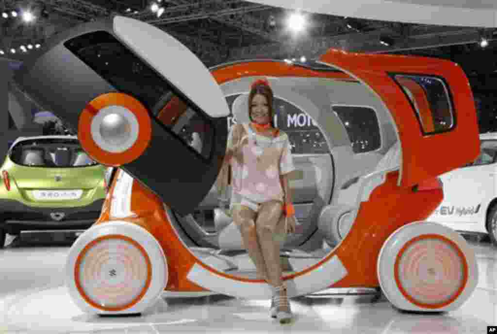 A model sits on Suzuki Motor Corp.,'s concept car "Q-Concept" during the press preview of Tokyo Motor Show in Tokyo, Wednesday, Nov. 30, 2011. The Tokyo Motor Show opens to the public this weekend. (AP Photo/Koji Sasahara)