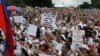 Tens of thousands of protesters flash thumbs down signs during a rally at Rizal Park Monday, Aug. 26, 2013 in Manila, Philippines, to call for the scrapping of a corruption-tainted development fund known as pork barrel, that allows lawmakers to allocate g