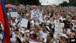 Tens of thousands of protesters flash thumbs down signs during a rally at Rizal Park Monday, Aug. 26, 2013 in Manila, Philippines, to call for the scrapping of a corruption-tainted development fund known as pork barrel, that allows lawmakers to allocate g