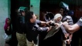 A police officer scuffles with a protester during clashes in Lahore, Pakistan. Police clashed with followers of an anti-Taliban cleric critical of the government in the eastern city, leaving at least seven people killed, officials said.