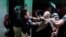 A police officer scuffles with a protester during clashes in Lahore, Pakistan. Police clashed with followers of an anti-Taliban cleric critical of the government in the eastern city, leaving at least seven people killed, officials said.