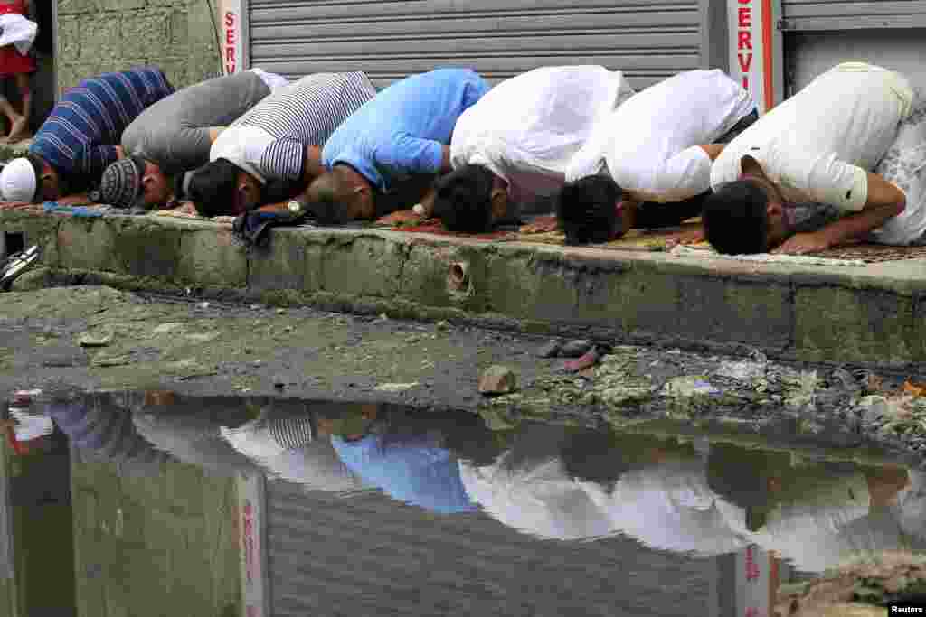Praying by the roadside in front of Al-Saite Mosque in Baseco, Tondo city, metro Manila, July 4, 2014.