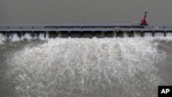 FILE- Workers open bays of the Bonnet Carre Spillway to divert rising water from the Mississippi River to Lake Pontchartrain, upriver from New Orleans, in Norco, La.. May 10, 2019. 