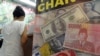 Tư liệu: Đồng đôla Mỹ,đồng rupiah của Indonesia và đồng nhân dân tệ của Trung Quốc trên một tấm quảng cáo tại một địa điểm đổi tiền ở Jakarta. 