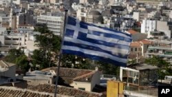 A Greek national flag flies in the city of Athens, May 8, 2015.