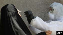 An Iraqi public hospital specialized doctor takes samples from Iraqi citizens in Baghdad's suburb of Sadr City as part of precautions against the spread of the novel coronavirus (COVID-19), April 2, 2020.