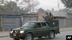 A Pakistani army vehicle patrols a street following a blast at a paramilitary camp in Bannu, Pakistan, December 24, 2011.