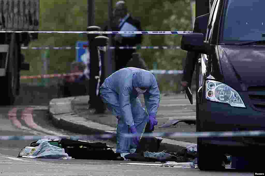 A police forensics officer investigates a crime scene where one man was killed in Woolwich, southeast London May 22, 2013.