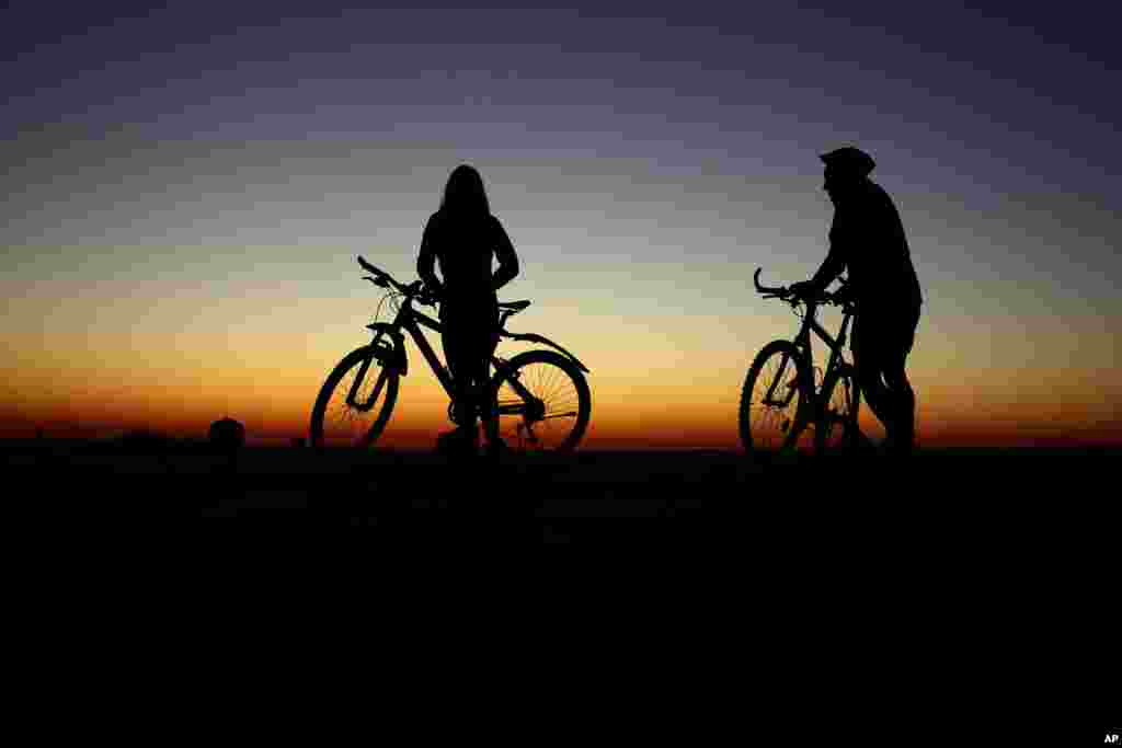 دو دوچرخه&zwnj;سوار با خیره شدن به شفق به انتظار طلوع خورشید در مونیخ آلمان ایستاده&zwnj;اند.