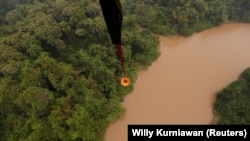 Helikopter MI-8MTV-1 dari Badan Nasional Penanggulangan Bencana (BNPB) membawa air untuk dibuang di hutan gambut yang terbakar di Kabupaten Pulang Pisau dekat Palangka Raya, Provinsi Kalimantan Tengah, 19 September 2019. (Foto: REUTERS/Willy Kurniawan)